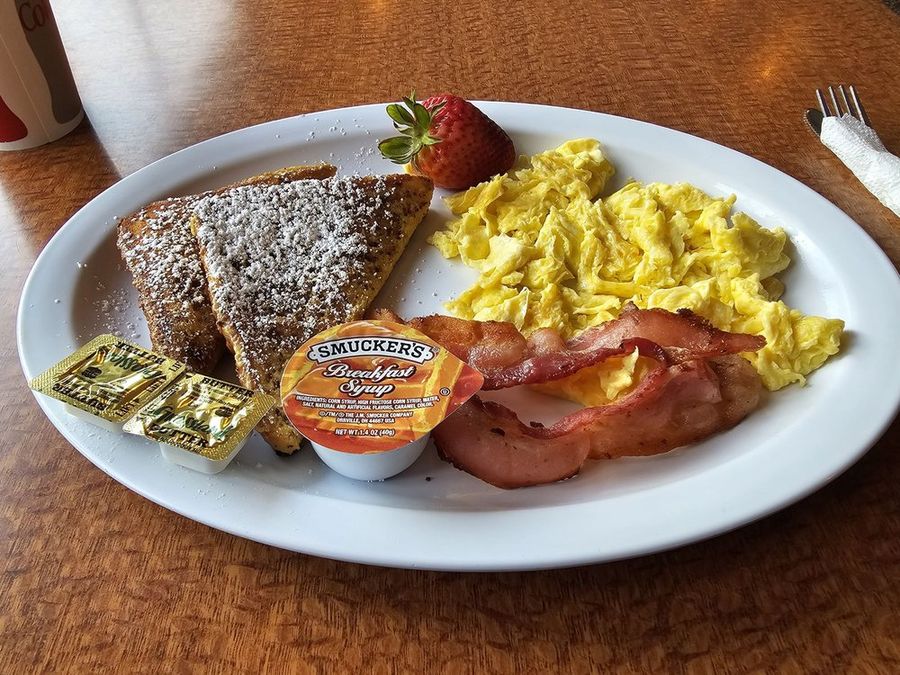 French toast breakfast plate at Pete's with scrambled eggs, bacon and a strawberry